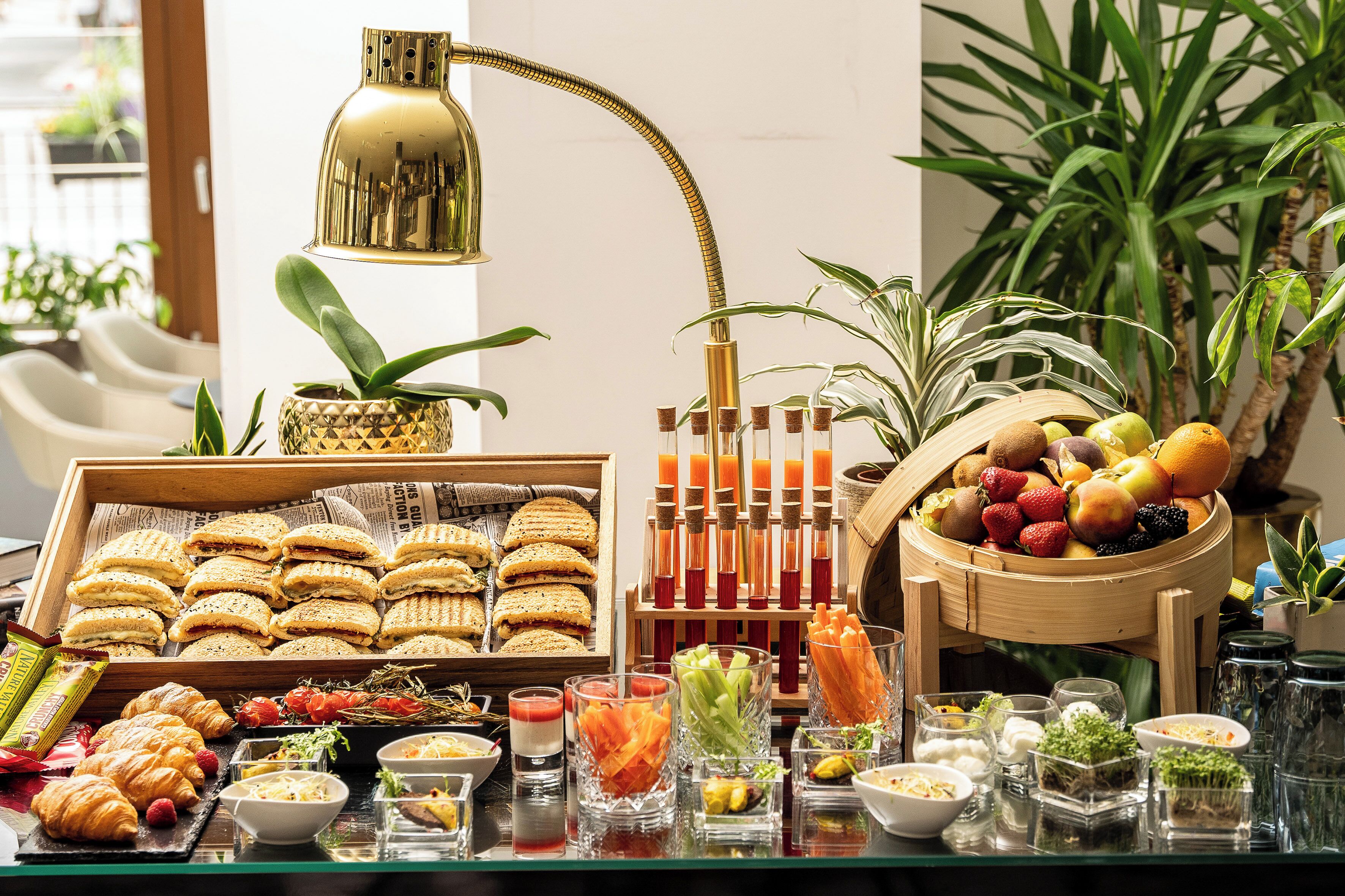 Un bufé con sándwiches, frutas y diversas bebidas.