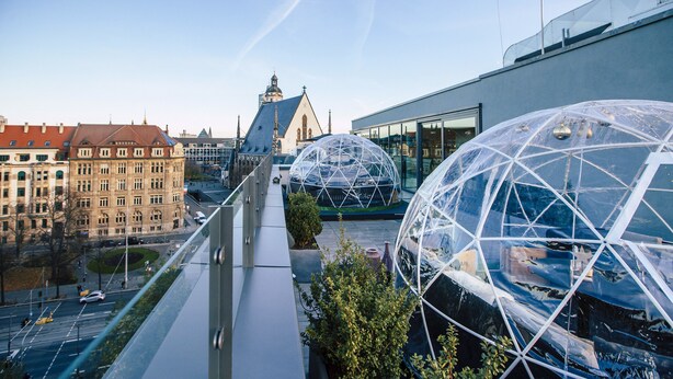 Un edificio moderno con cúpulas transparentes grandes y fachada de vidrio.