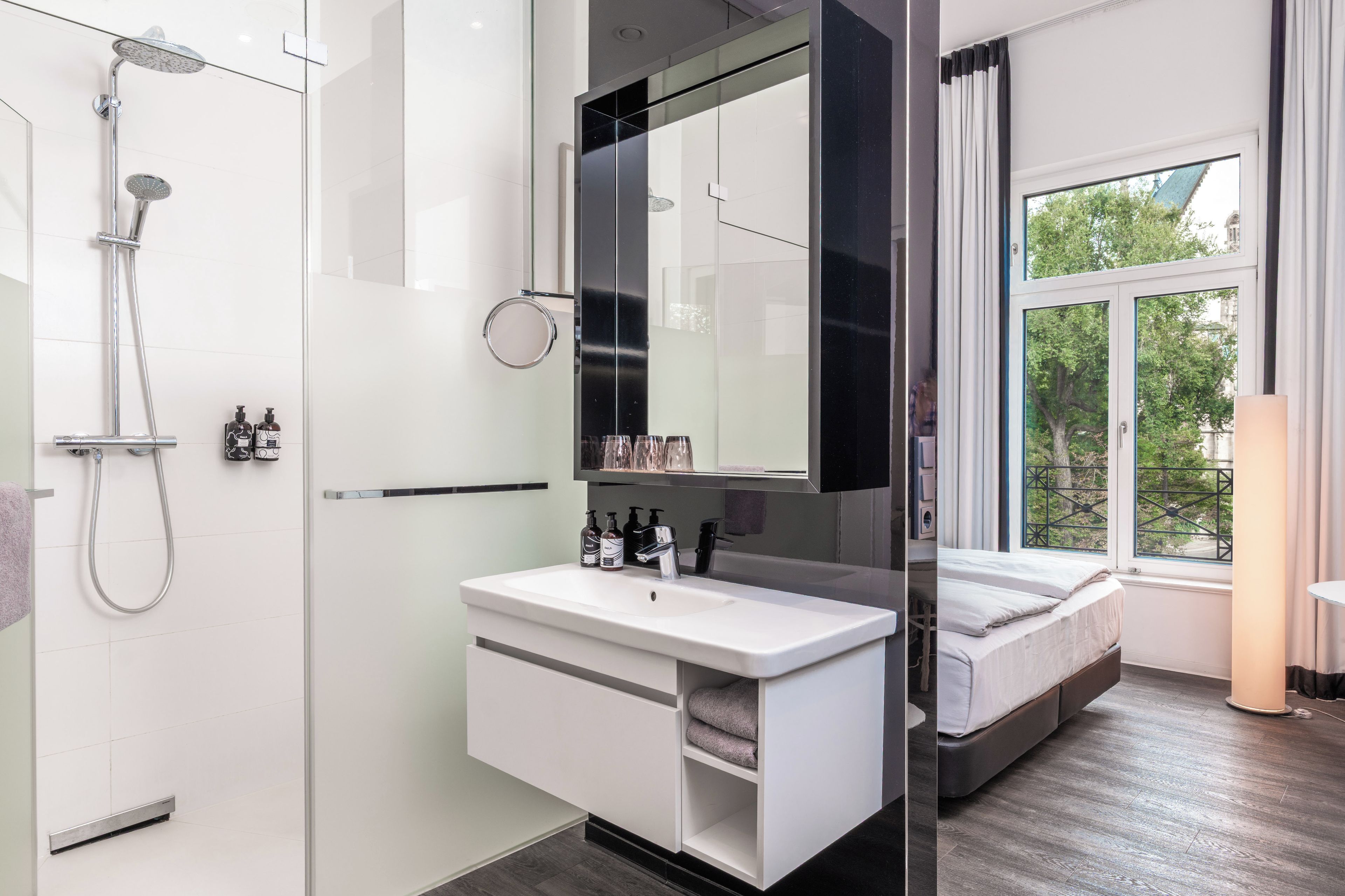 Ein modernes Badezimmer mit Dusche, Waschbecken und Spiegel.