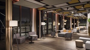 Un área de estar moderna con sofás, sillones y una zona de bar.