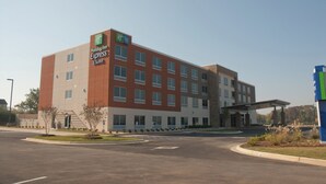 Ein Holiday Inn Express & Suites Hotel mit modernem architektonischen Design, gekennzeichnet durch ein flaches Dach und eine Fassade aus Backstein und Glas.