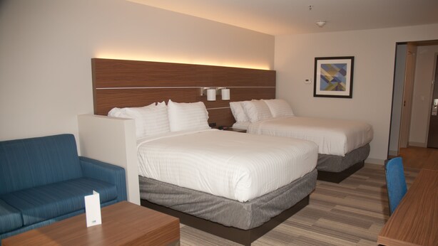 A hotel room with a large bed, a smaller bed, a sofa, a desk, and a wall-mounted light fixture. - Holiday Inn Express & Suites Decatur by IHG (Decatur)