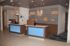 A reception area with two counters, a wall-mounted sign, and a security camera.