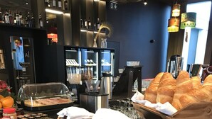 A buffet counter with various food items, including bread and pastries, and a selection of beverages. - VISIONAPARTMENTS Zurich Militärstrasse (Zürich)