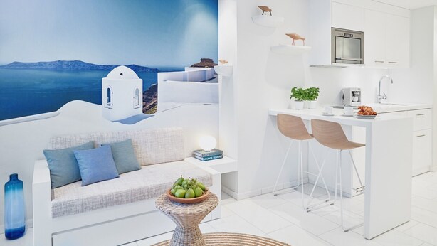 A modern kitchen with white cabinetry, a built-in oven, and a dining area with two chairs. - VISIONAPARTMENTS Zurich Militärstrasse (Zürich)