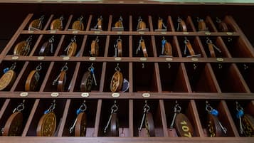 Un perchero de madera con varias filas de llaves, cada una identificada con un número.