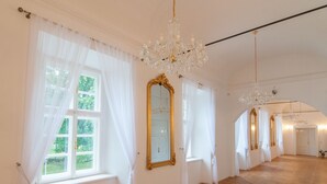 A spacious room with large windows, ornate chandeliers, and a parquet floor. - Zámek Jeseník nad Odrou (Jesenik nad Odrou)