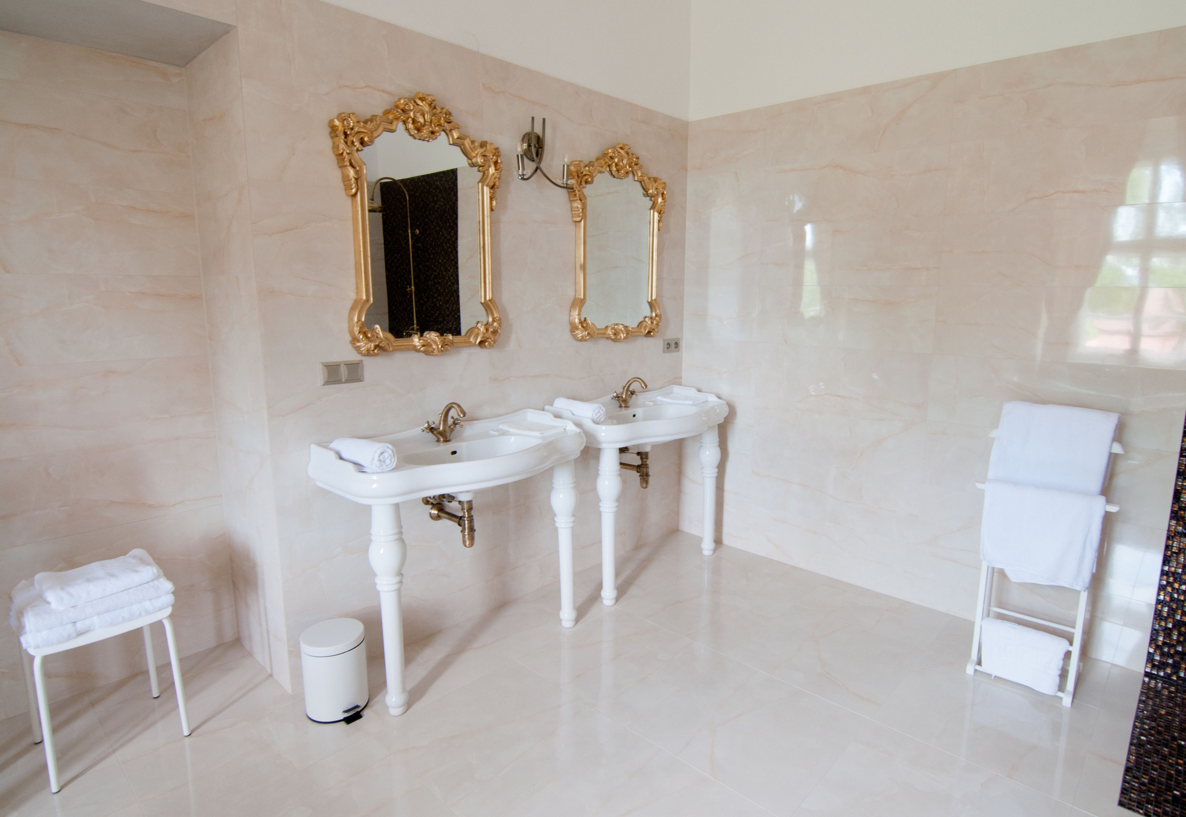 A bathroom with two sinks, a vanity, and a towel rack.