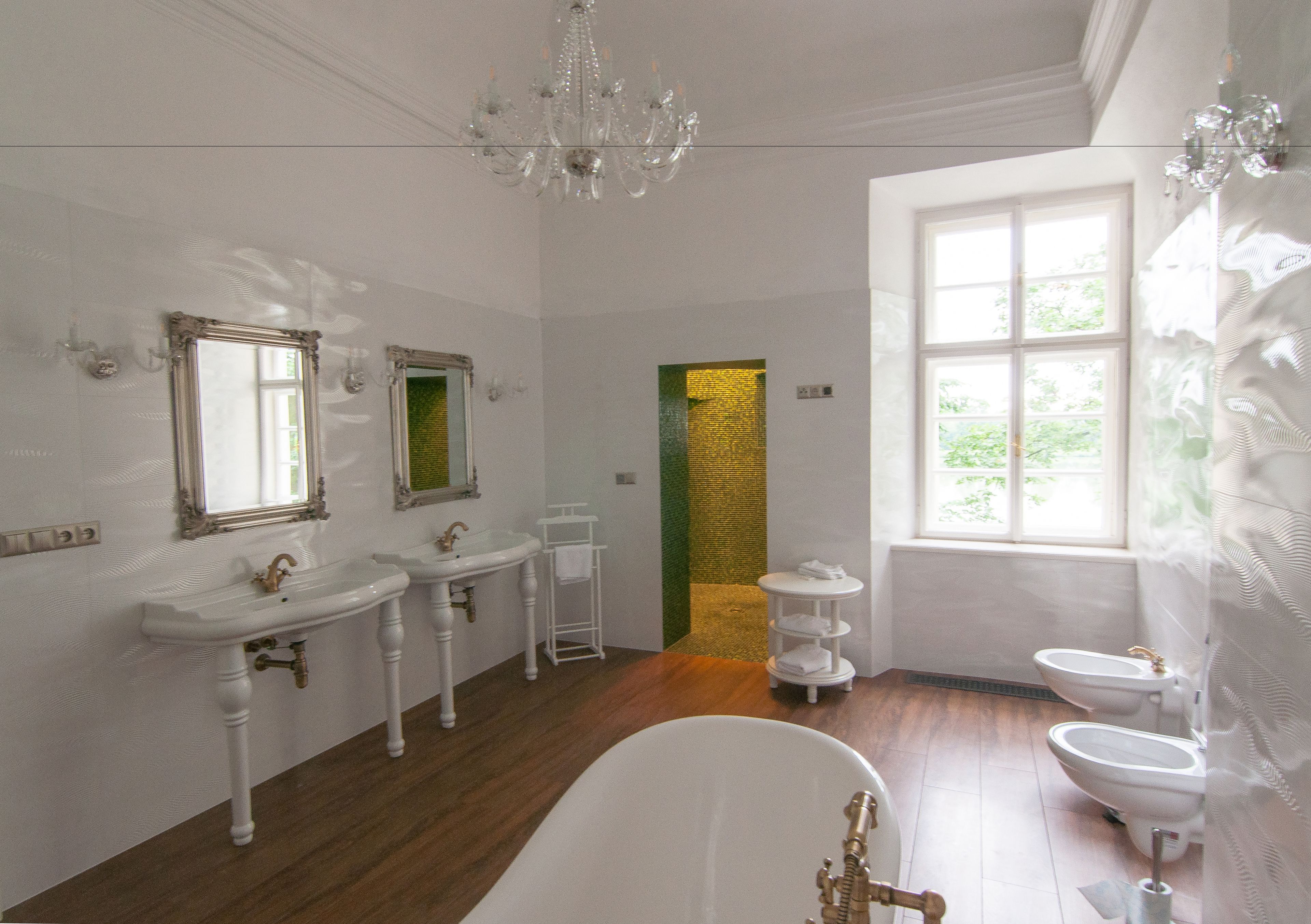 A bathroom with two sinks, a bathtub, and two toilets.