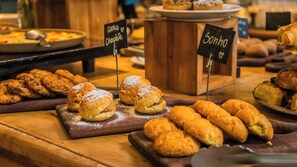 Une variété de pâtisseries et de desserts étaient présentées sur des planches en bois, accompagnées de panneaux indiquant les différents types.