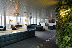 A modern lounge area with seating arrangements and a large window providing natural light.
