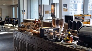 A breakfast bar with various food items and a self-serve pancake maker.