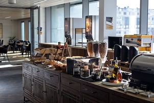 A breakfast bar with various food items and a self-serve pancake maker.
