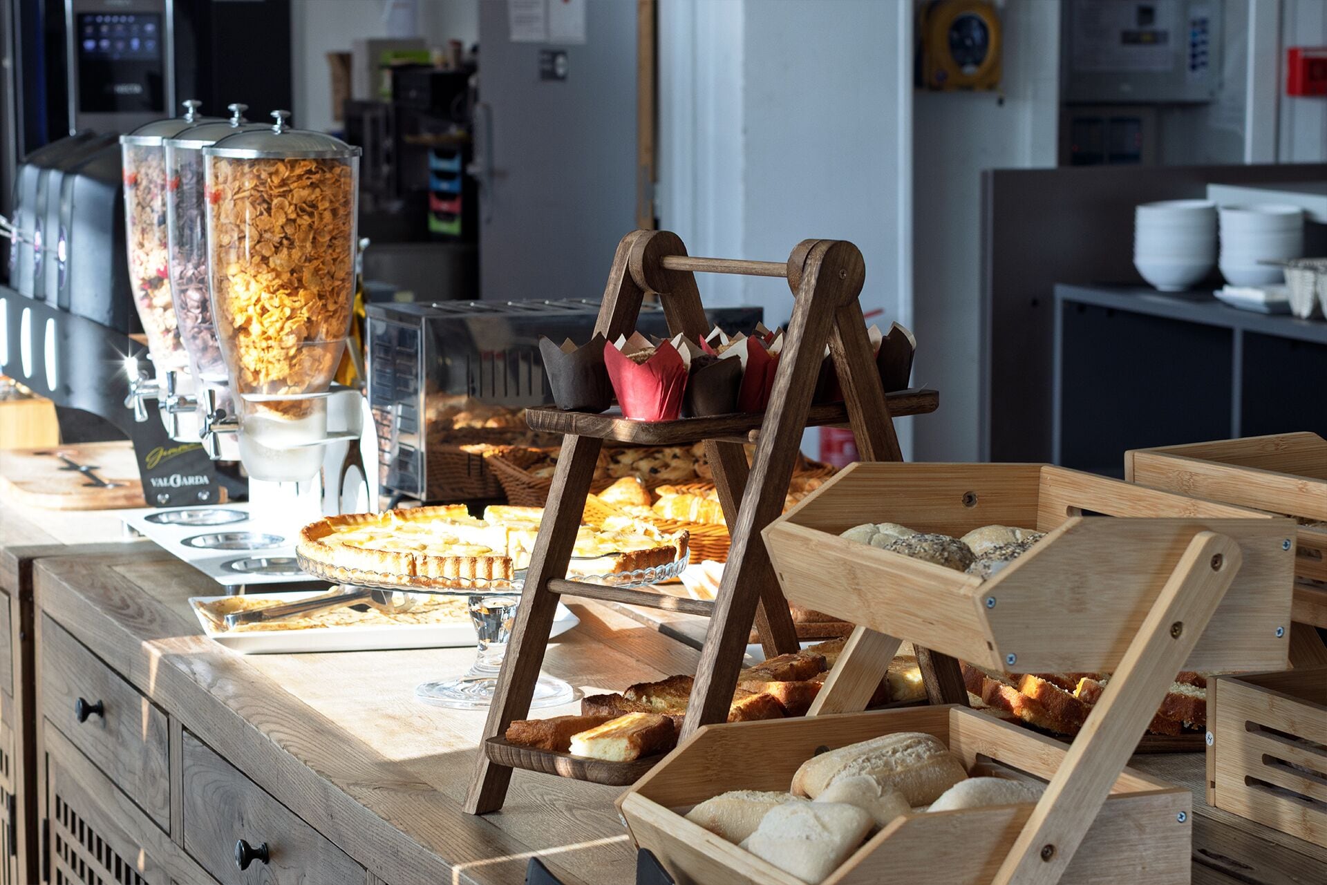 Una barra de panadería con diversos productos horneados, incluyendo pan y bollería, y una máquina de café.