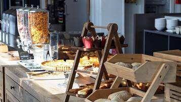 Una barra de panadería con diversos productos horneados, incluyendo pan y bollería, y una máquina de café.