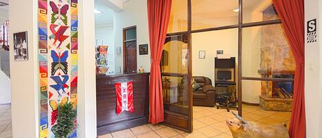 A reception area with a colorful wall design, a reception desk, a potted plant, and a bull statue.