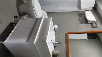 A modern bathroom with a toilet, bidet, and a large mirror.