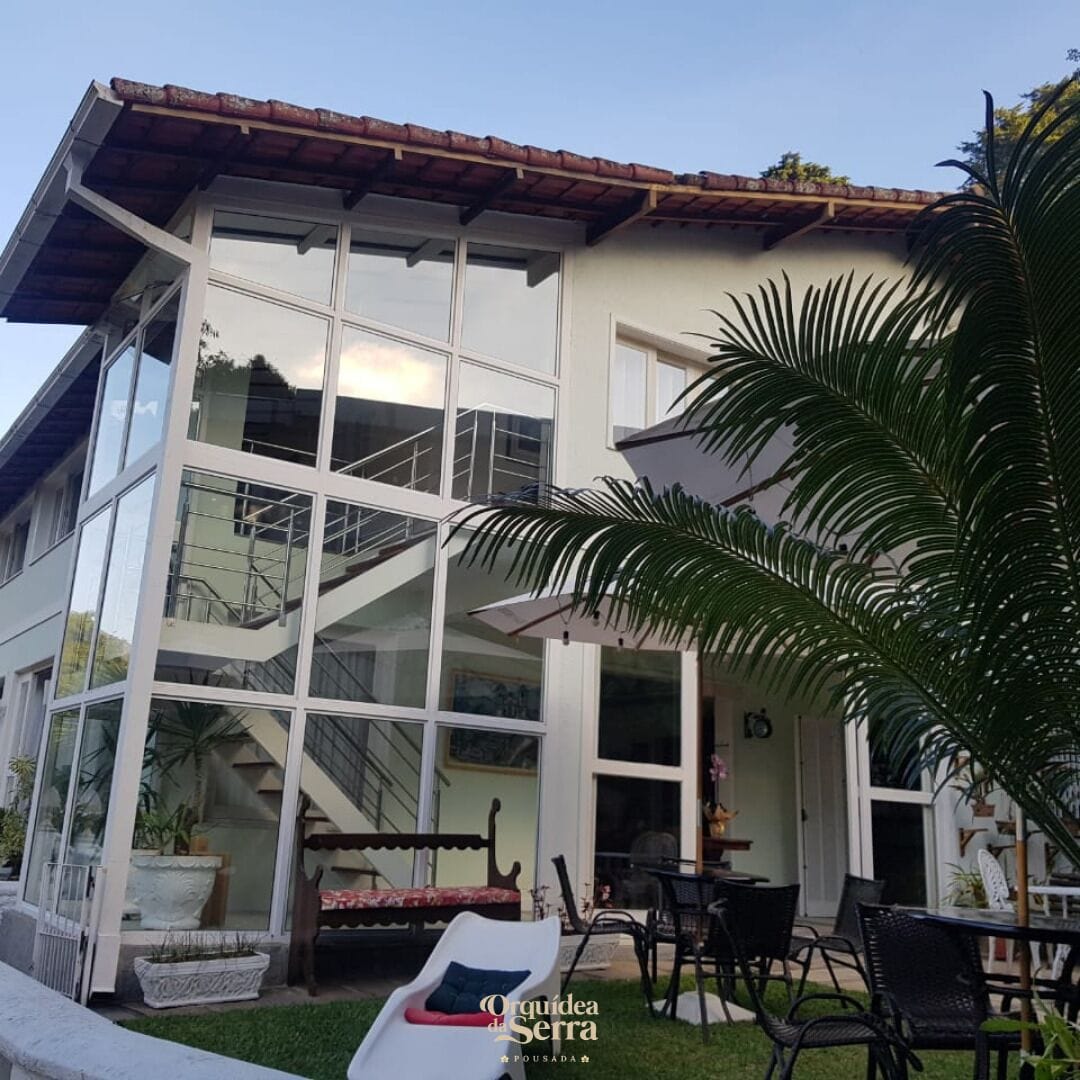 Un edificio moderno con amplios ventanales, una escalera y zona de estar al aire libre.