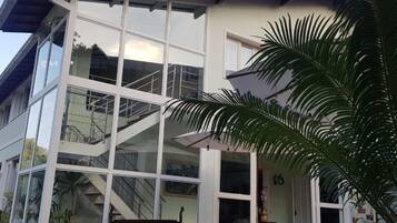 Un edificio moderno con amplios ventanales, una escalera y zona de estar al aire libre.