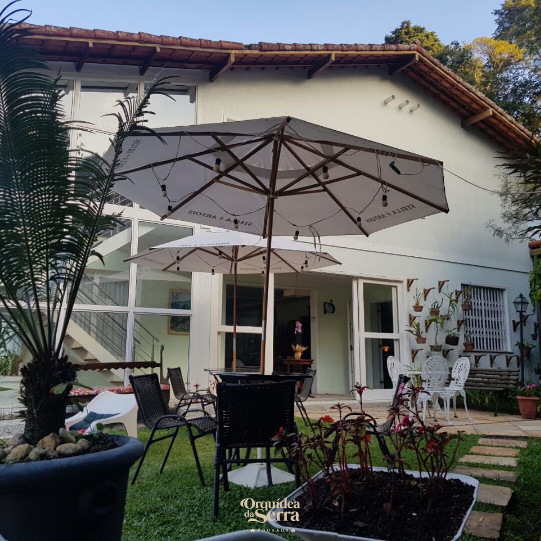 An outdoor patio area with a large umbrella, chairs, and potted plants.