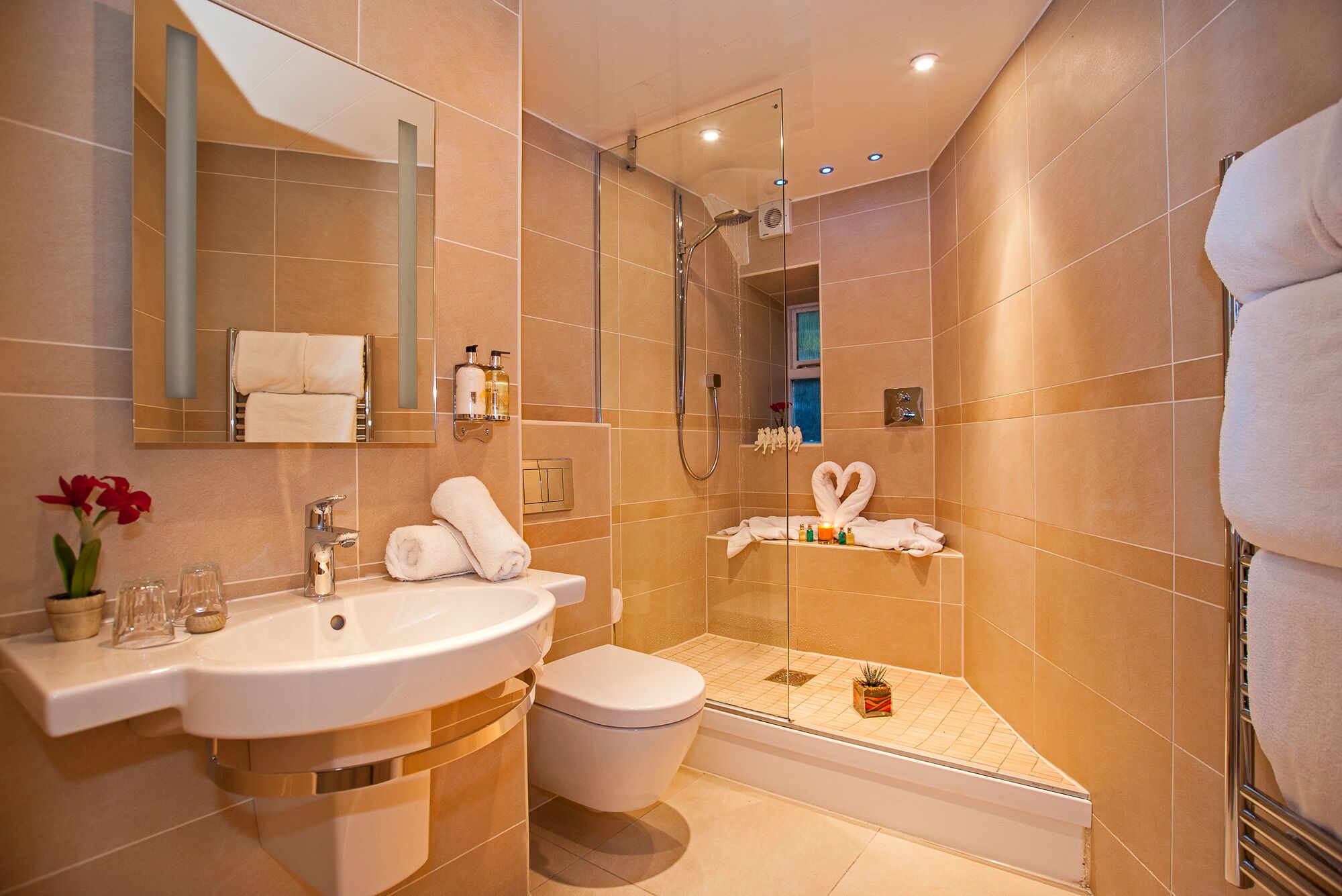A modern bathroom with a sink, toilet, and shower.