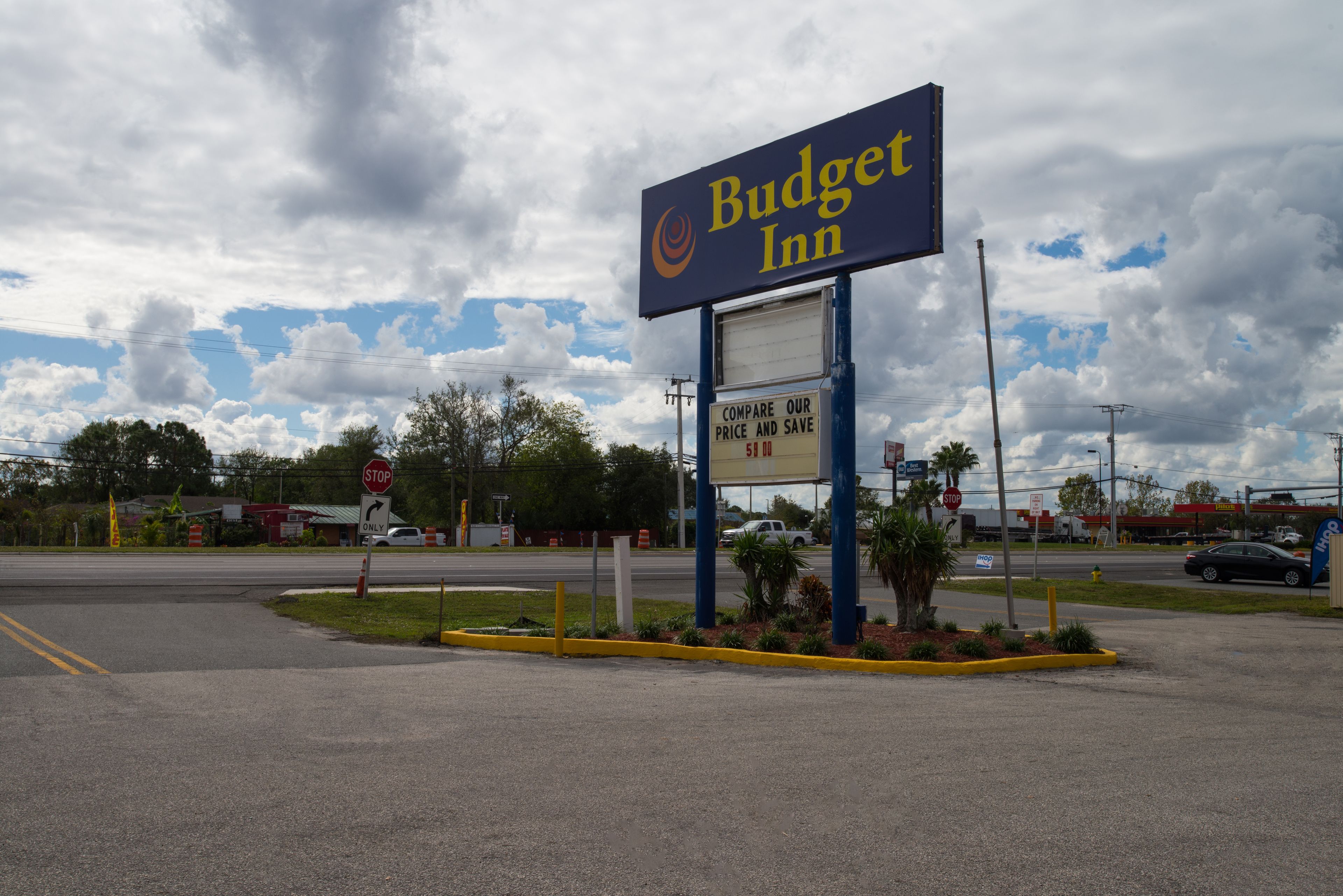 A Budget Inn sign with a 'compare our price and save' advertisement.