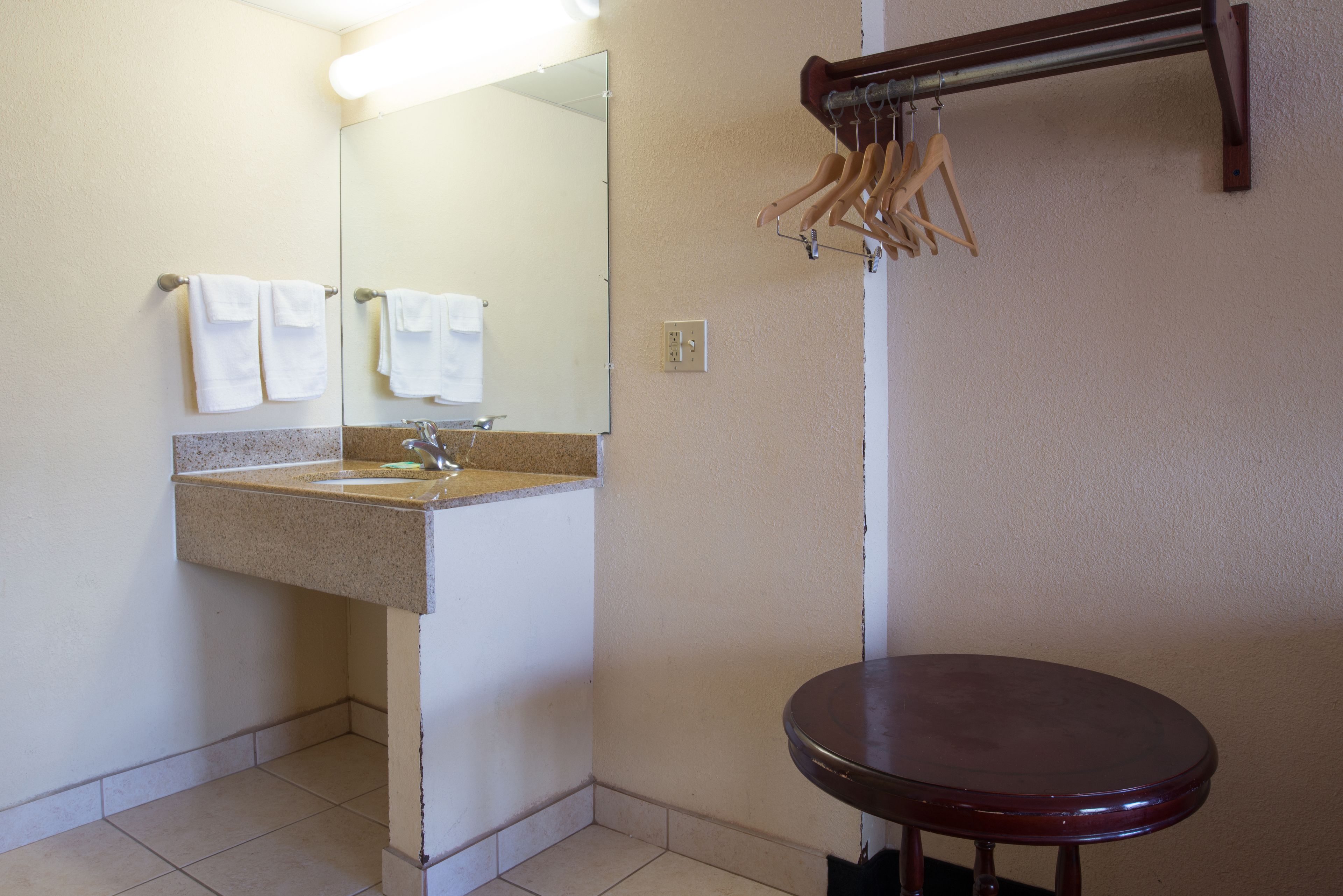 Ein Badezimmer mit Waschbecken, Spiegel, Handtuchhalter und Toilette.