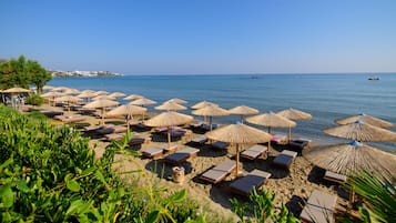 On the beach, sun-loungers, beach towels, windsurfing