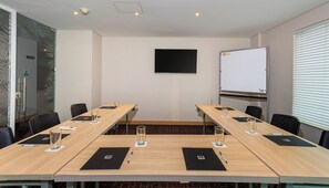 A conference room with a long table, chairs, a whiteboard, and a projector screen. - BH Barranquilla (Barranquilla)