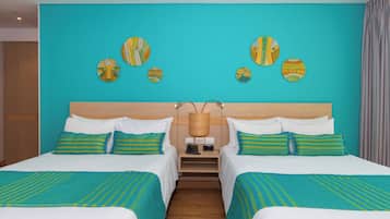 Habitación de hotel con dos camas, un cabecero de madera y una pared decorada con platos.