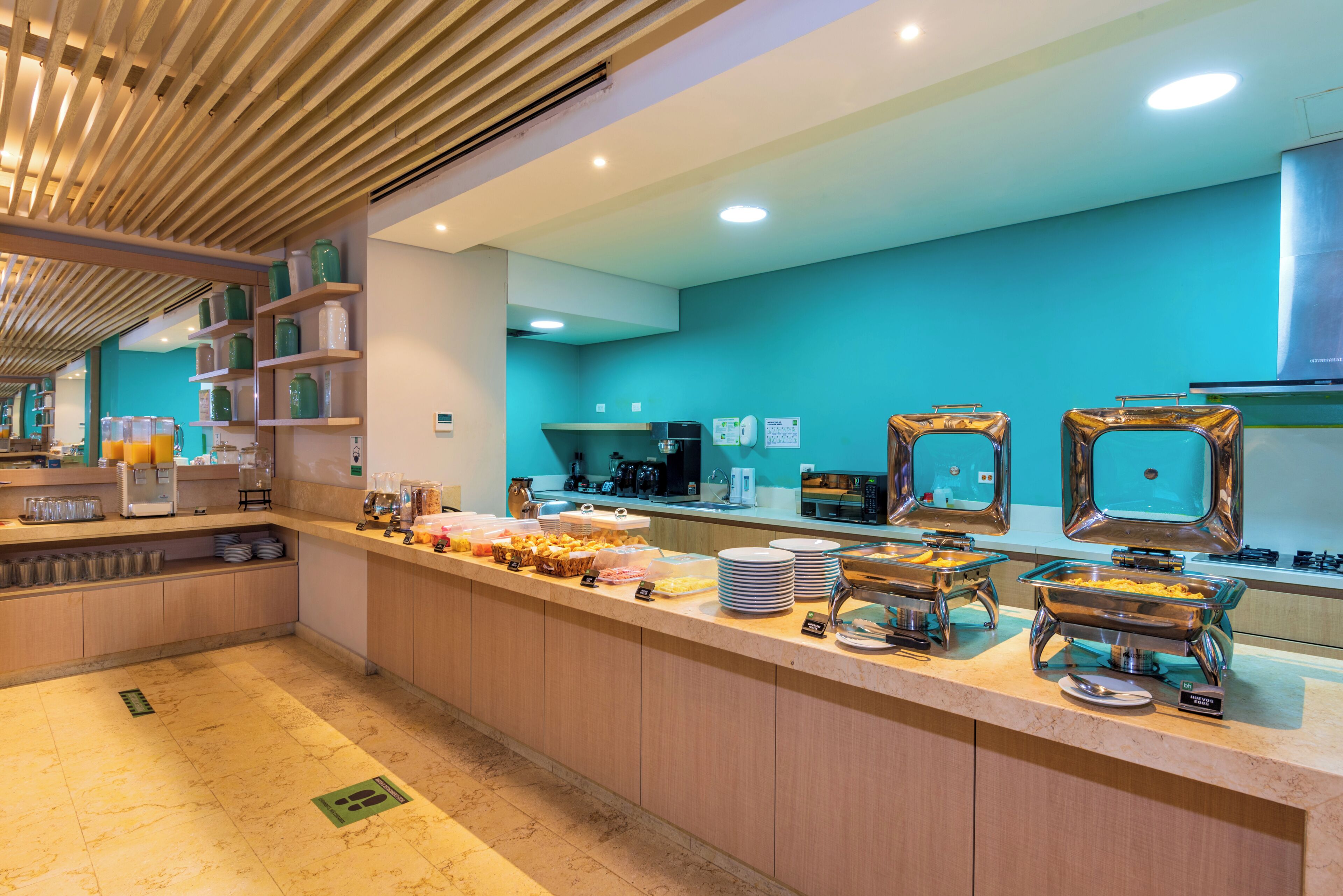 Un área de bufé con diversas opciones de comida, una estación de café y un microondas.