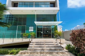 A modern hotel entrance with a glass facade, a visible nameplate, and a staircase leading to the entrance. - BH Barranquilla (Barranquilla)
