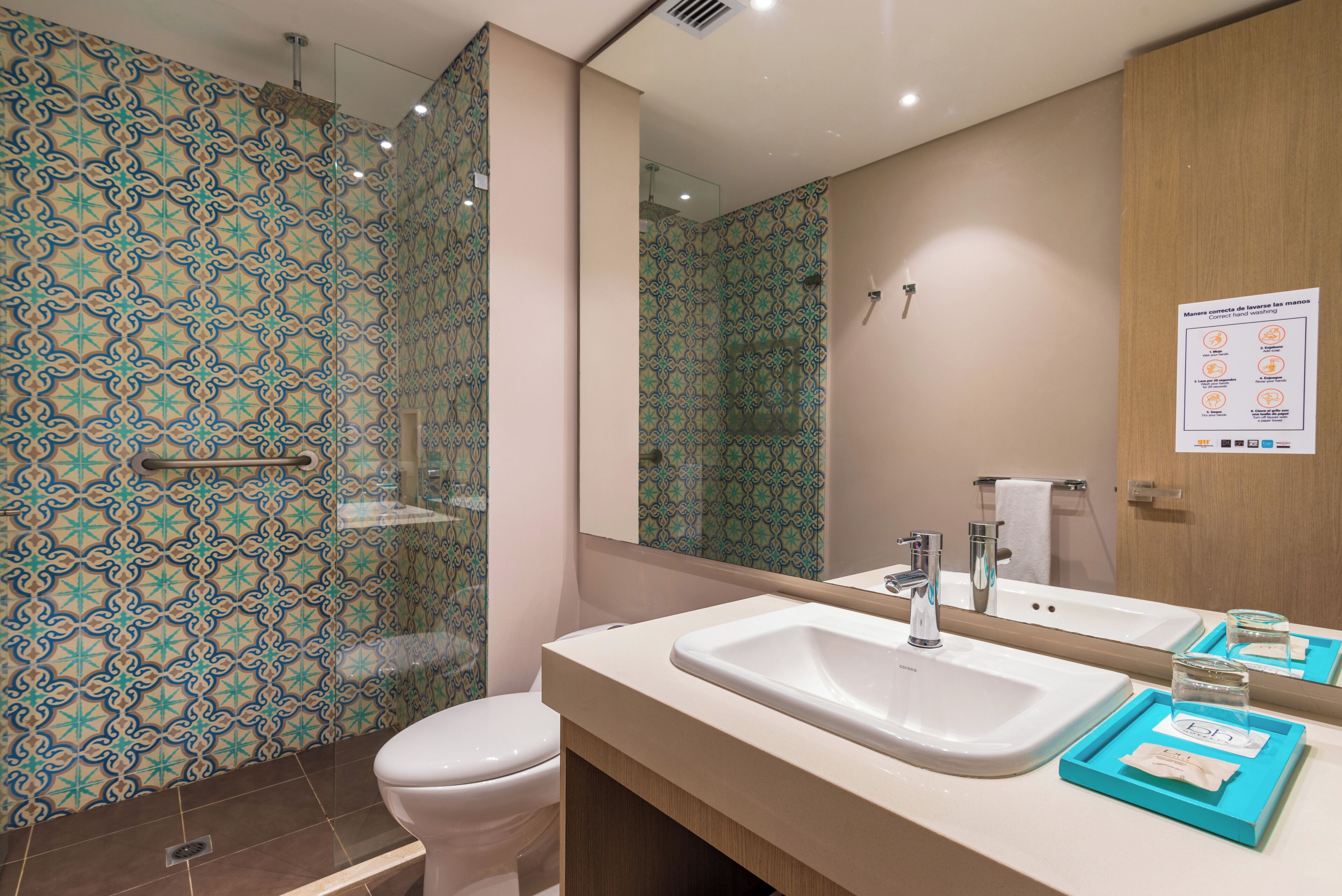 Une salle de bain équipée d’une douche, de toilettes, d’un lavabo et d’un miroir.