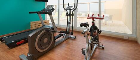 A gym with cardio machines, a treadmill, and a stationary bike.