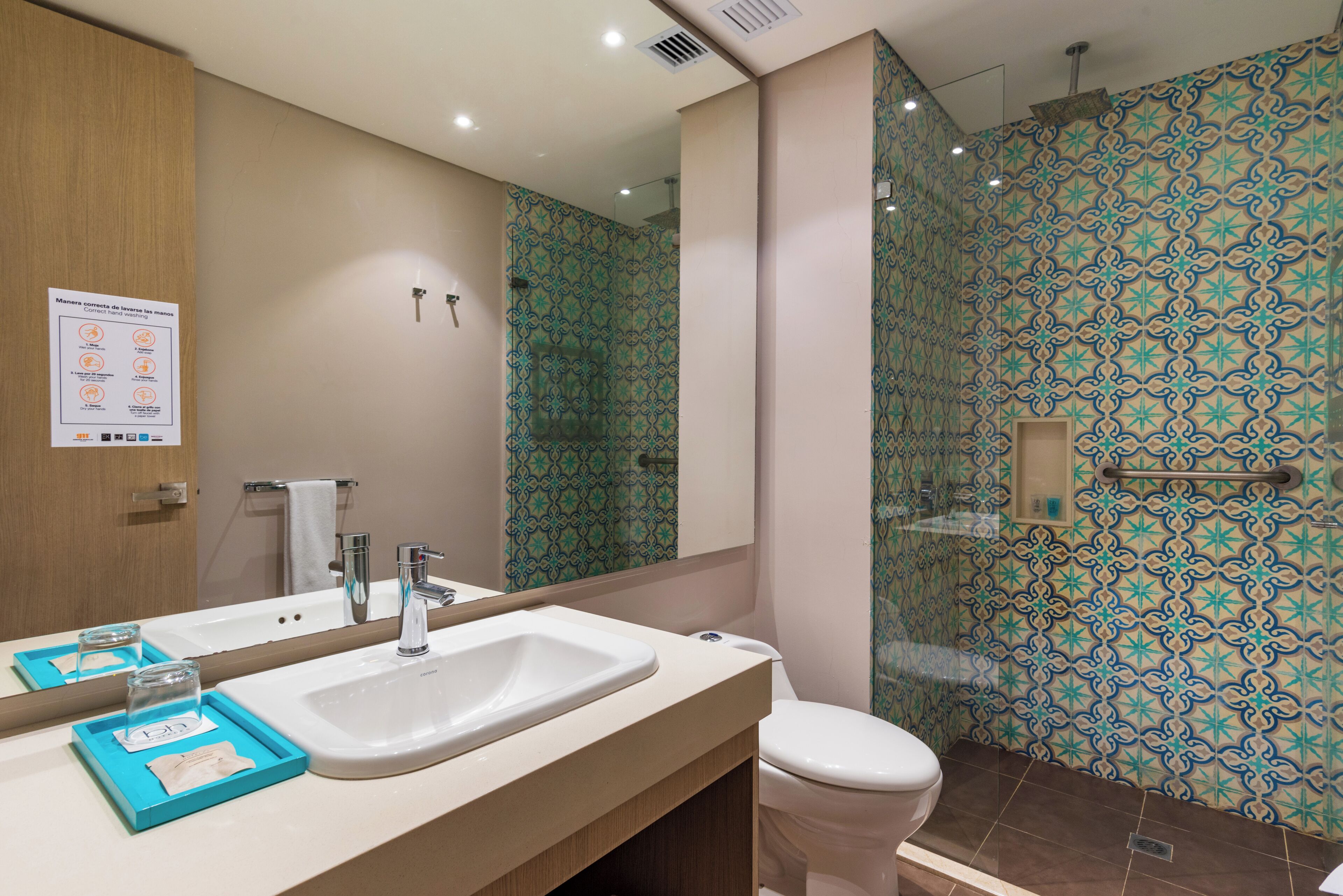 A bathroom with a sink, mirror, and a shower area.