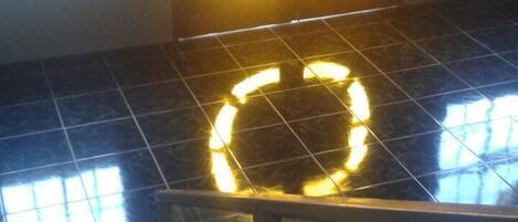A staircase with a circular light fixture on the wall.