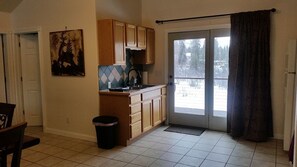 A kitchen with wooden cabinets, a sink, and a window with curtains.