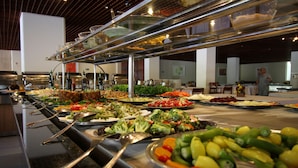 Un bufé con diversos alimentos y utensilios de servicio.