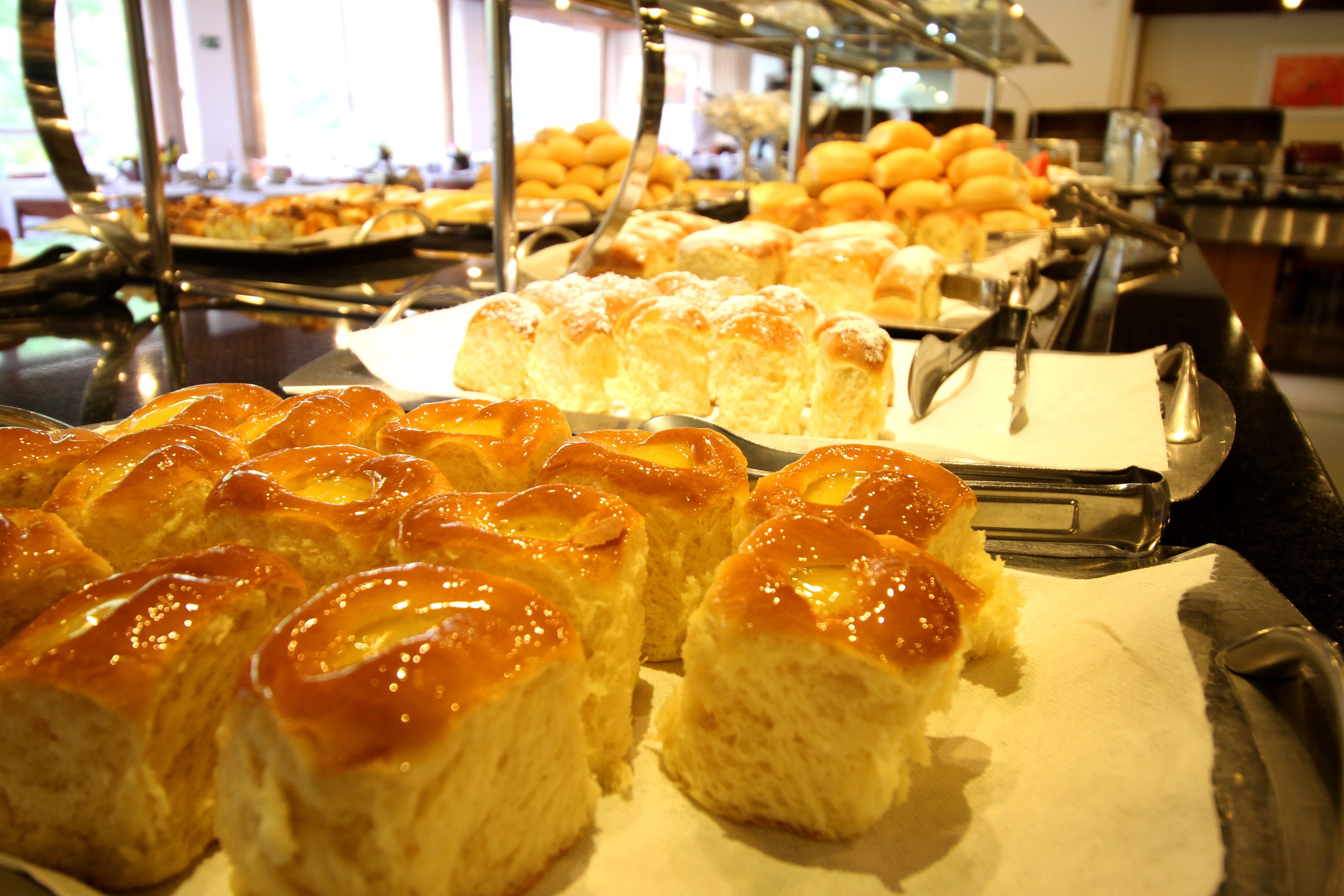 A buffet with various baked goods, including pastries and bread.