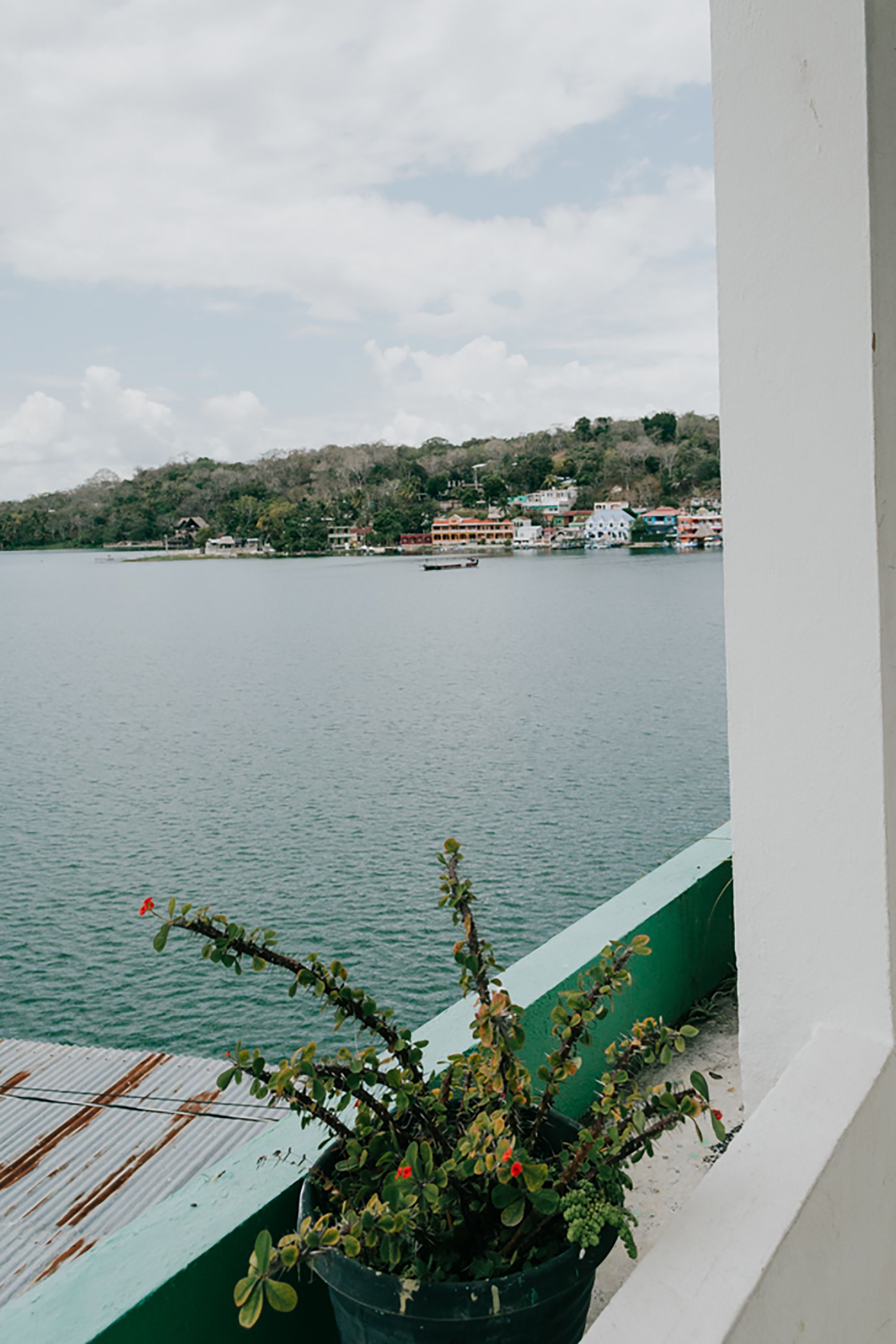 A view of a calm lake with buildings on the opposite shore.