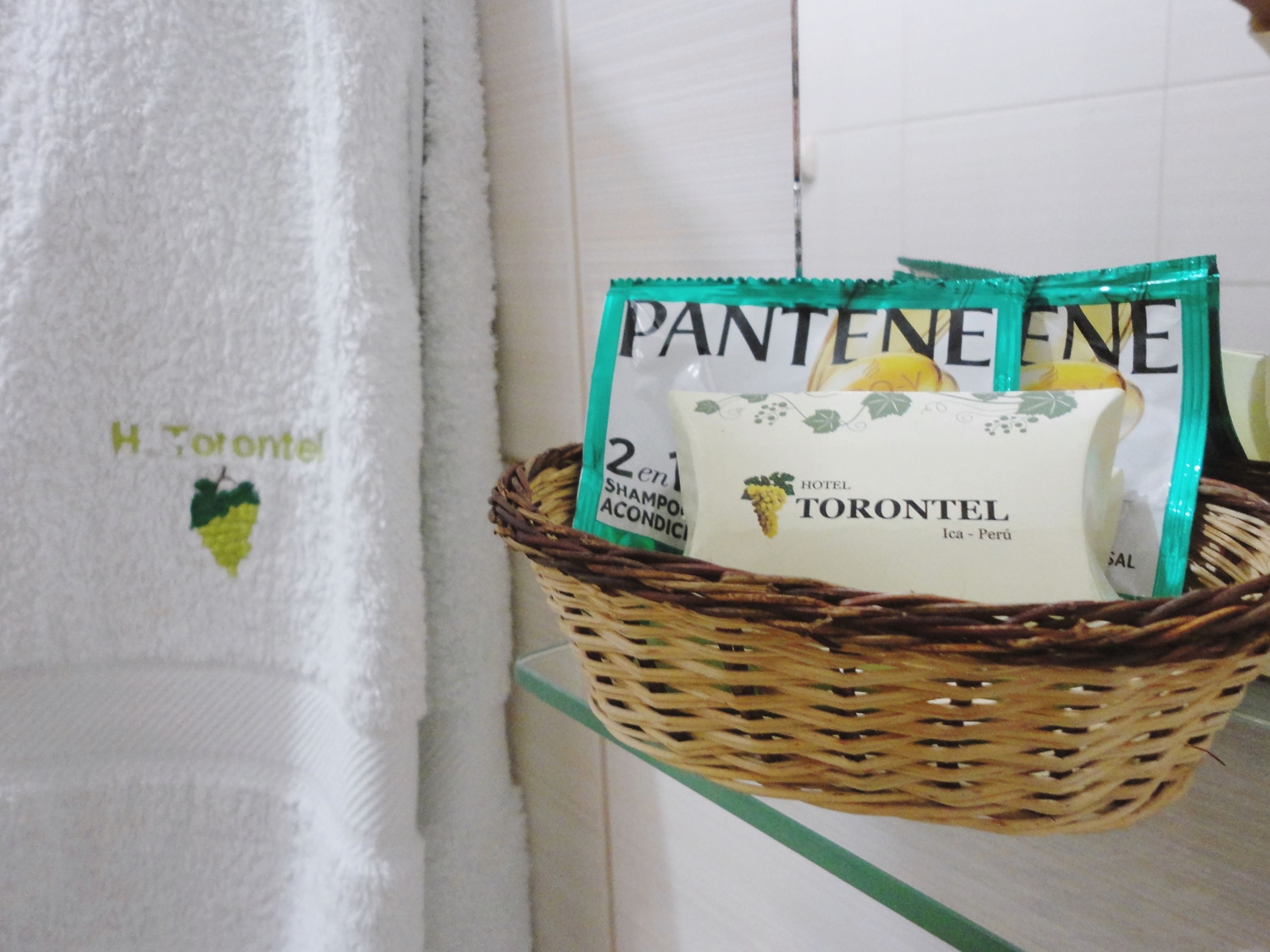 A wicker basket with Pantene hair care products on a glass shelf.