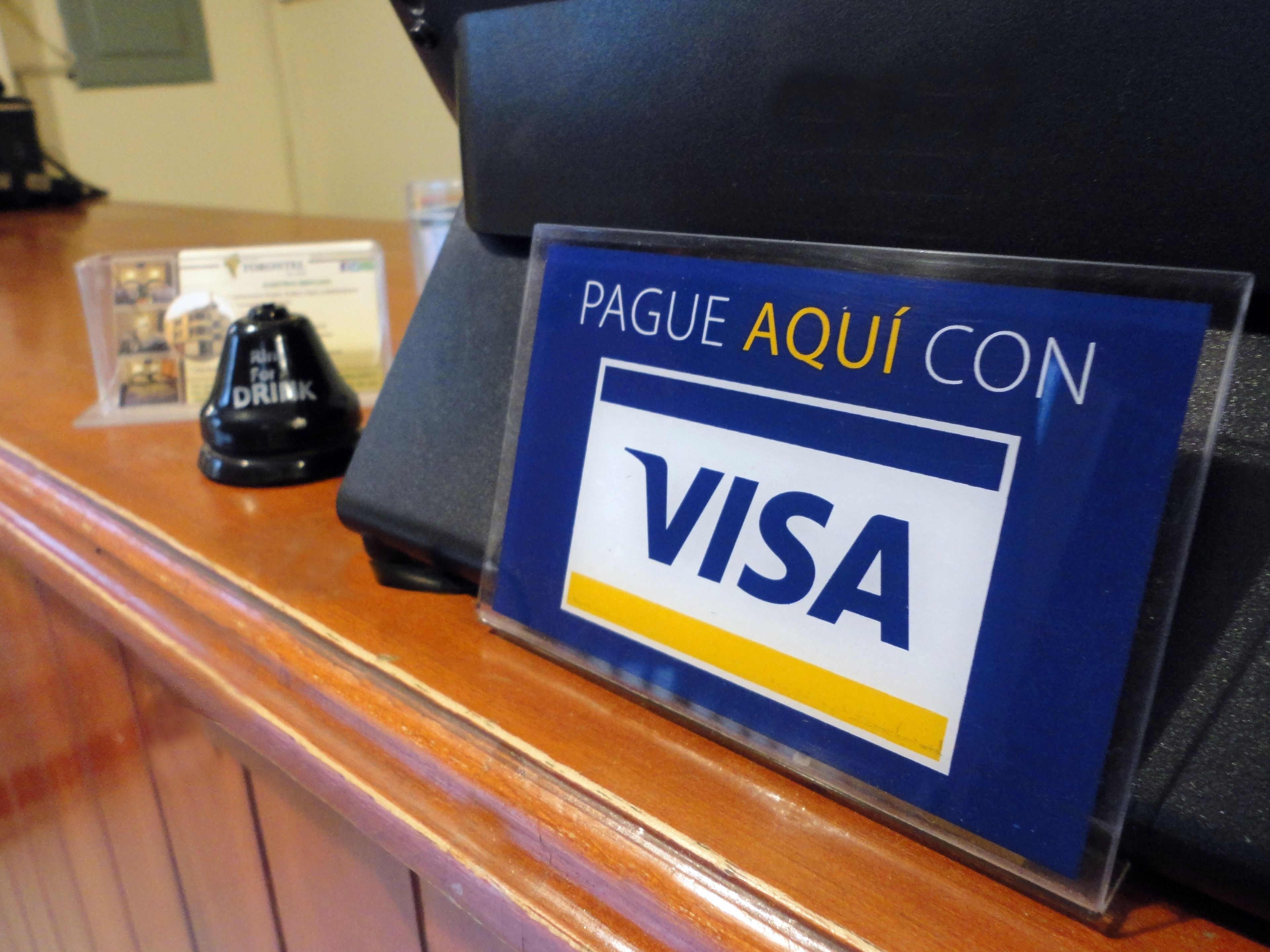 A reception desk with a sign indicating payment acceptance for VISA.