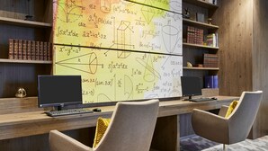 A study area with two desks, chairs, and a large wall covered in mathematical equations. - Hampton by Hilton Oxford (Oxford)