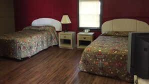 A room with two beds, a nightstand with a lamp, a telephone, and a television. - Morgan City Motel (Morgan City)