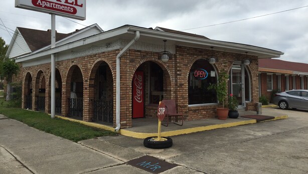 A motel with a brick facade, arched windows, and a Coca-Cola sign. - Morgan City Motel (Morgan City)