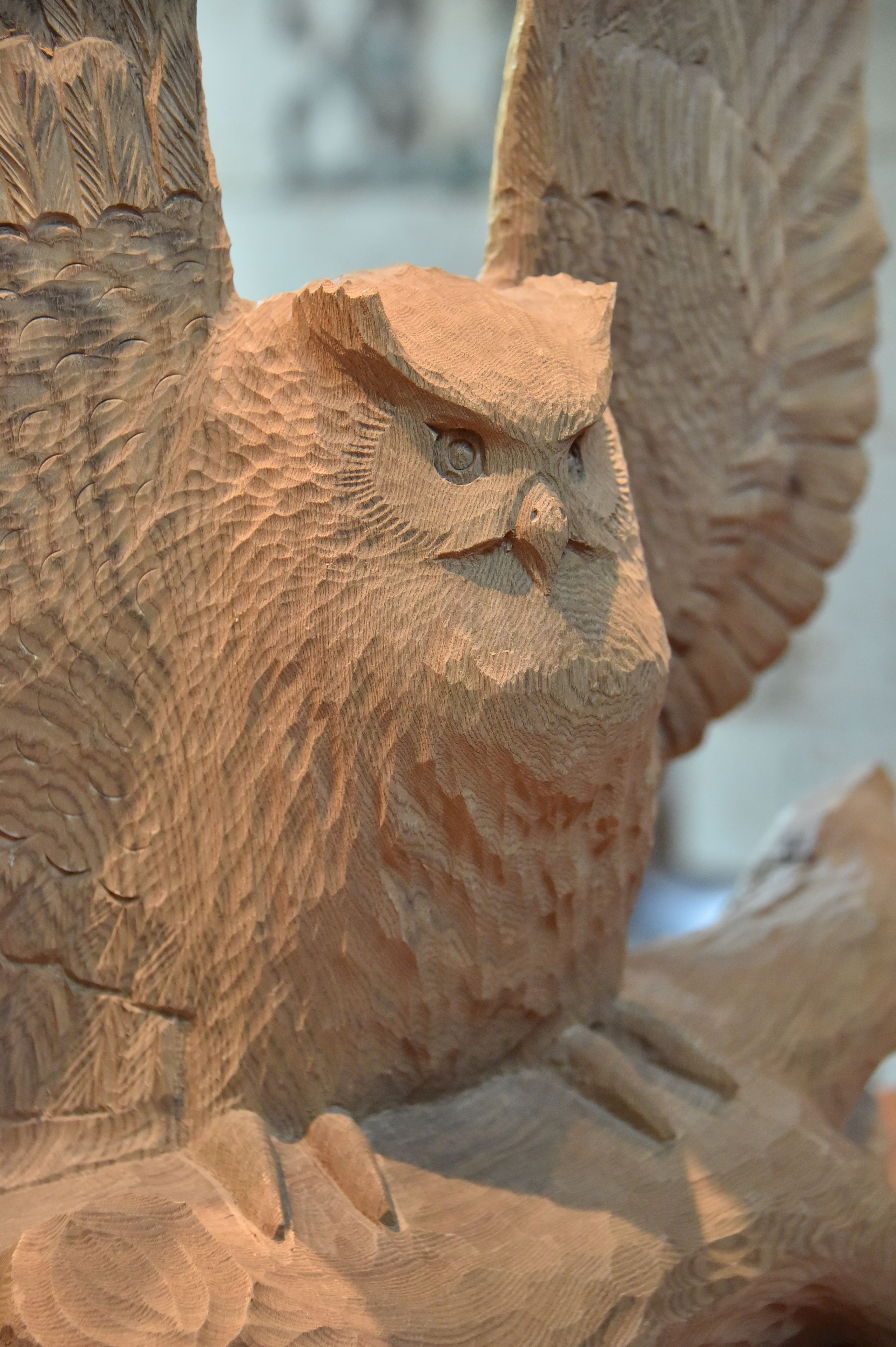 Une sculpture en bois détaillée représentant une chouette, ornée de motifs complexes.