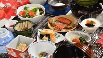 Una variedad de platos japoneses en una bandeja, incluyendo sushi, sashimi y un tazón de sopa.