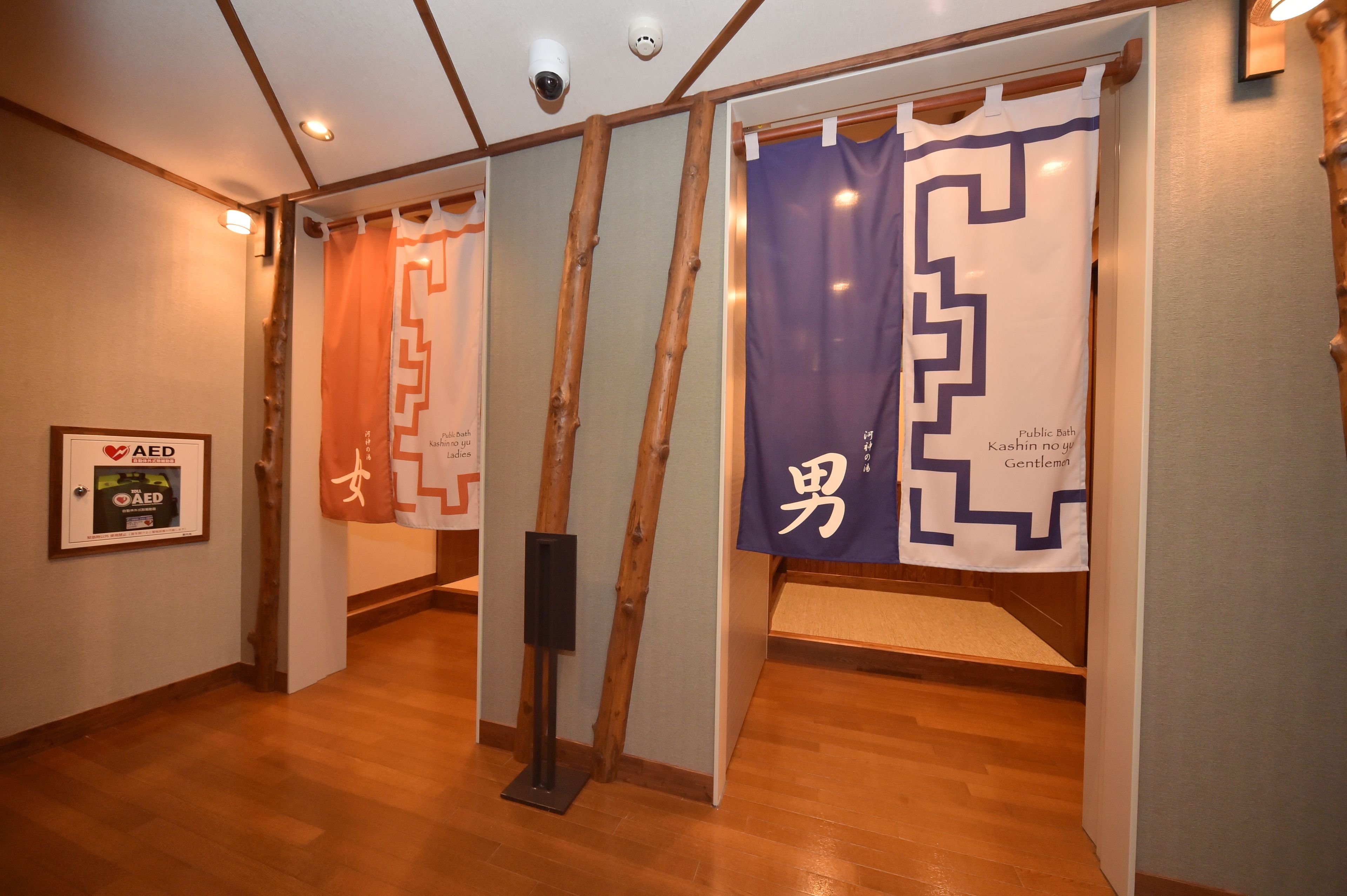 Un pasillo con piso de madera, un letrero enmarcado de DEA y dos pancartas con texto en japonés.