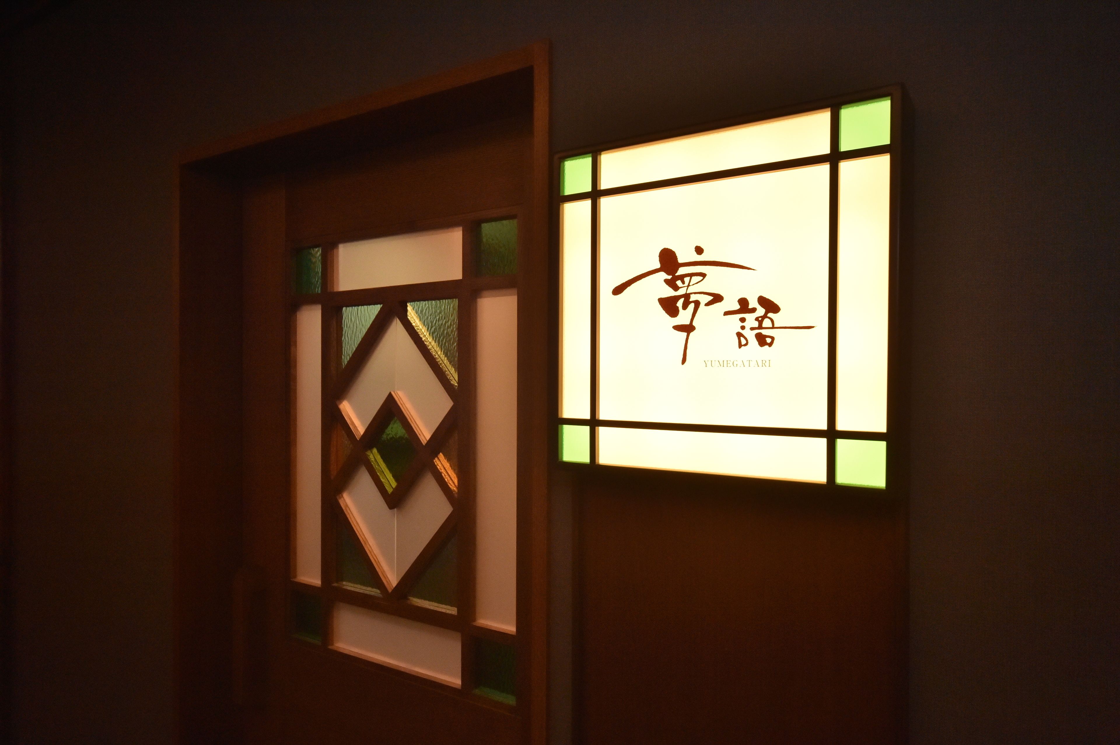 A wall with a framed artwork and a lit-up sign with Chinese characters.