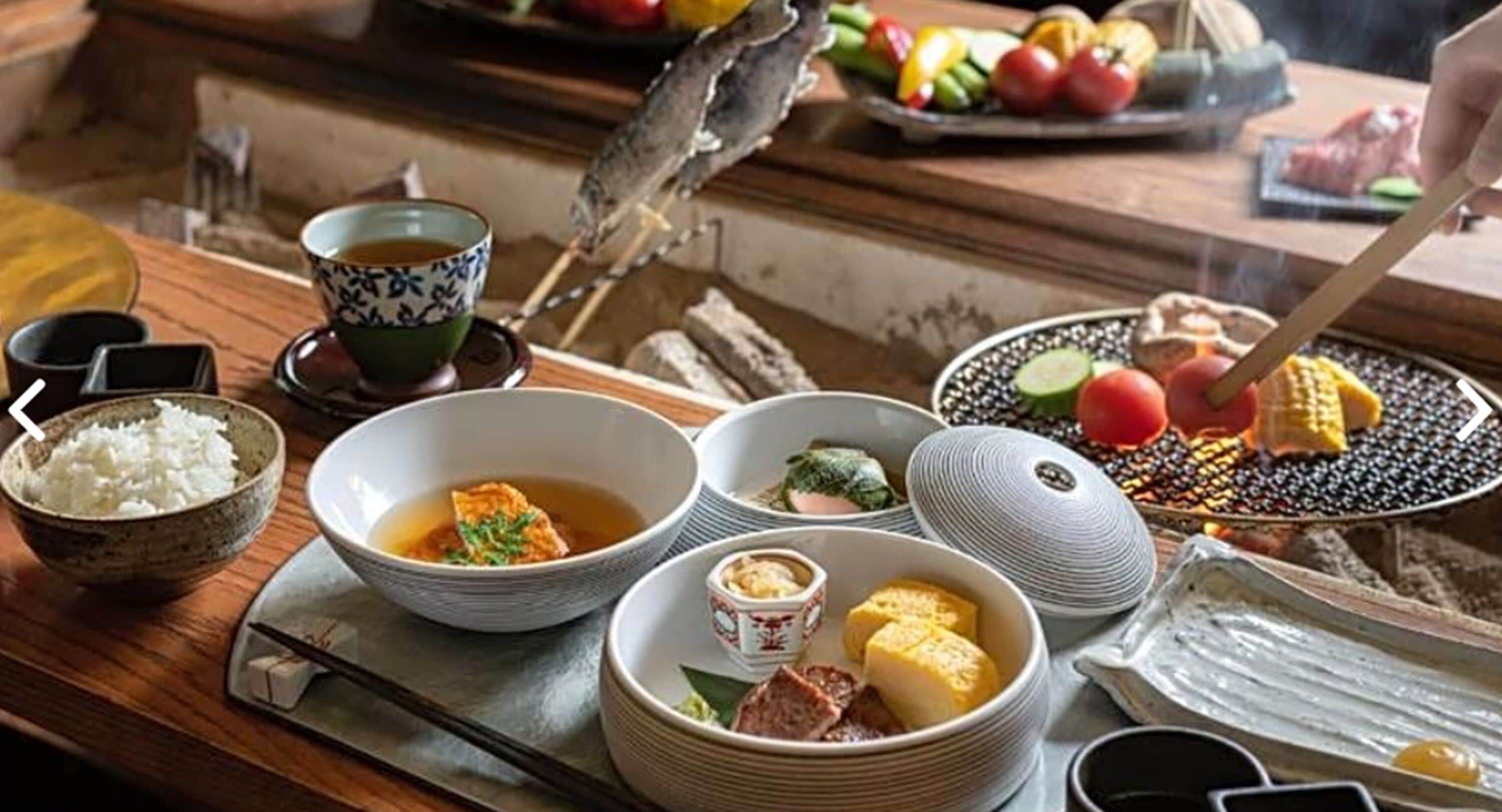 A traditional Japanese meal setup with various dishes, including rice, soup, and grilled vegetables.